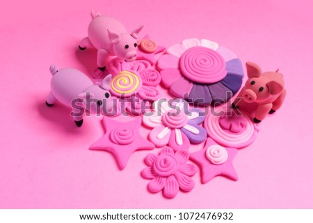 Three piglets. Cute pink pigs of plasticine on a white background.