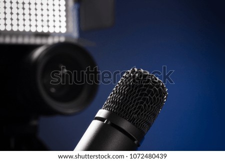 black microphone and camera with lens and led panel on 
