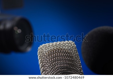 Close-up of silver microphone - camera in the background