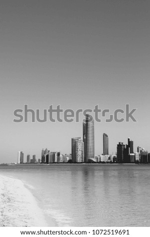 Abu Dhabi sky line modern skyscrapers city scene from white sand beach on marina island. United Arab Emirates
