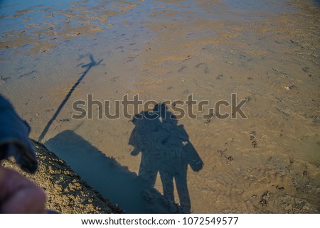 Love concept: shadow of women and of men on the beach sand 