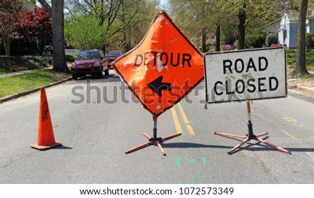 DETOUR and ROAD CLOSED signs on residential neighborhood street.