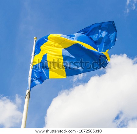 Swedish flag waving in the wind on a blue sky background