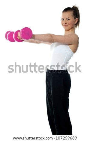 Pretty teenager working out with dumbbells. Shot in studio on white background