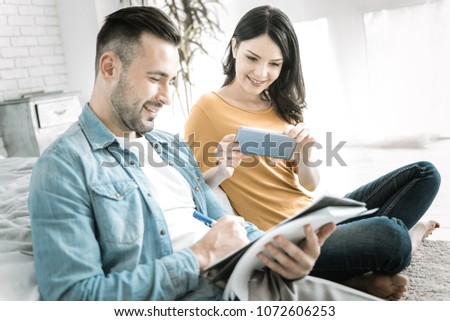 Educational material. Happy joyful two students sitting while woman taking photo and using smartphone