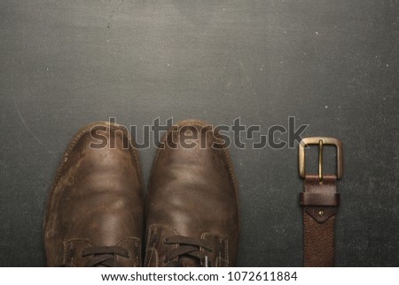 classic brown shoes and belt on wooden table. vintage picture