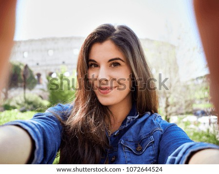Content young woman in denim jacket taking selfie smiling at camera in city of Rome.