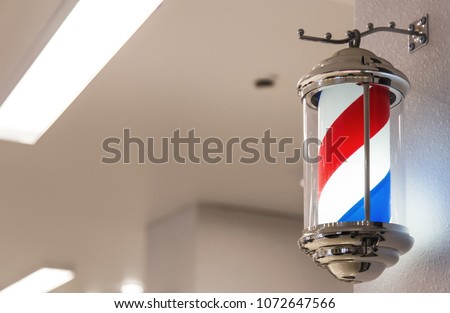Barber's pole on the background of the interior of the barbershop