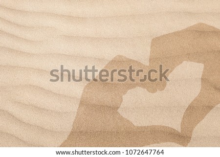Shadow of hand sign heart on sand background.Hands in shape of love heart,Love ,Valentine's day concept.
