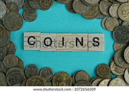 Word coins  from wooden letters on a green background 