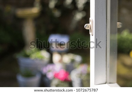 Open window onto a garden on a sunny day. Good morning and have a happy day! It is a view from inside on the blurred background of blossom nature.