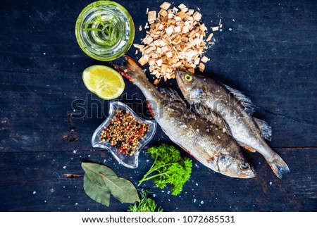 Raw fish Cooking background, fish on the black old wooden rustic table.Preparations to smoke, top view. Healthy food or diet concept