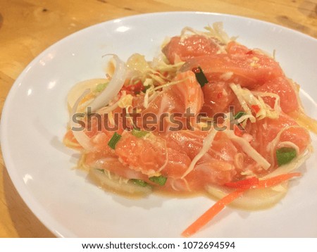 Salmon yum on a white plate with ingredients raw Salmon and raw materials to make and mix well.