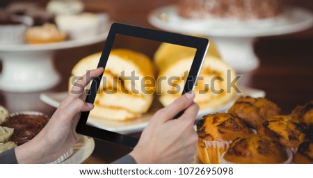 Digital composite of Hands taking picture of sweet food with tablet PC in coffee shop
