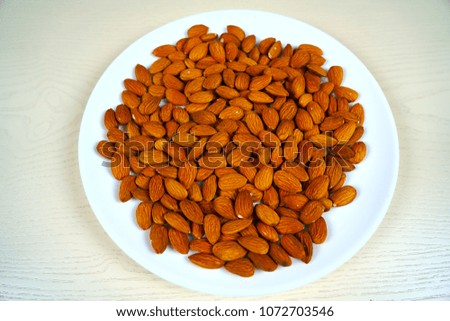 Almonds nuts on a white plate close-up