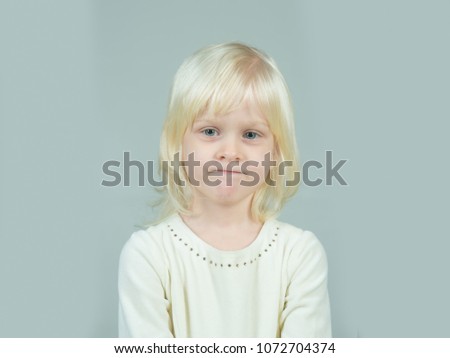 Little girl with young tender skin. Kid with blonde hair. Childhood and happiness of innocent girl. Fashion style and beauty look. Child with happy face and blond hair on grey background.