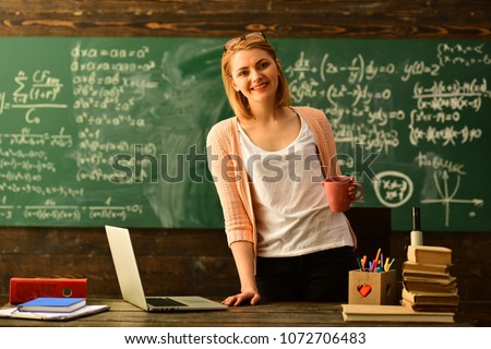 E-Learning concept with student holding his modern laptop computer, Tutor needs to be enthusiastic and needs to like his subject, Teacher drawing at classroom in school, Royalty-Free Stock Photo #1072706483