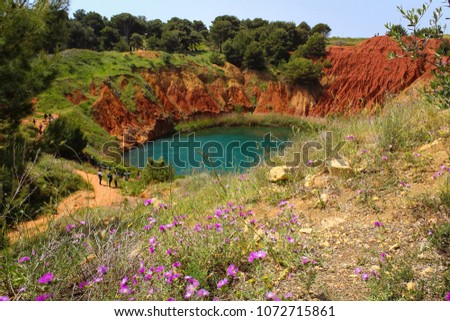 Emerald lake in old bauxite's quarry, surrounded by nature. Otranto, Salento, Puglia, Italy