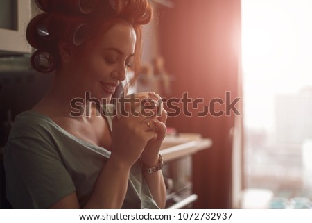 Pregnant woman emotions concept. Living feelings while drinking a cup of tea near the window with city reflection in it. Female silhouette profile picture.