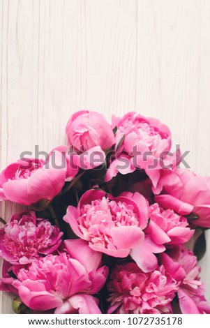 lovely pink peonies bouquet on rustic white wooden background top view, space for text. floral greeting card mock-up, flat lay. happy mothers day concept. spring image. pink flowers