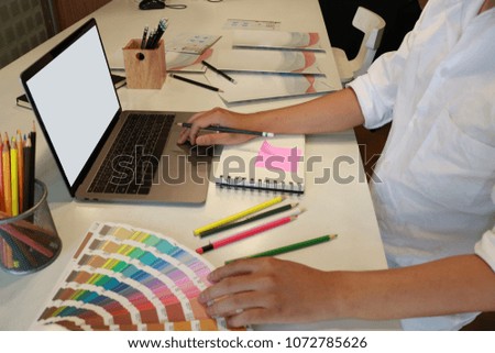 Young man working on laptop and taking notes
