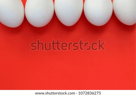 A few white eggs on a bright red background