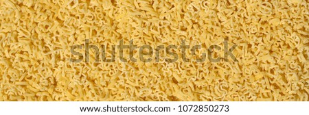 Texture of a lot of curly raw yellow pasta