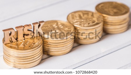 Wooden RISK word with golden coin on white table top