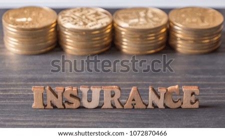 INSURANCE text with golden coin on table top