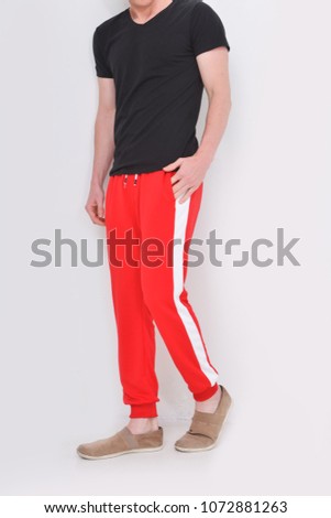 Person in red and white pants and shoes posing
