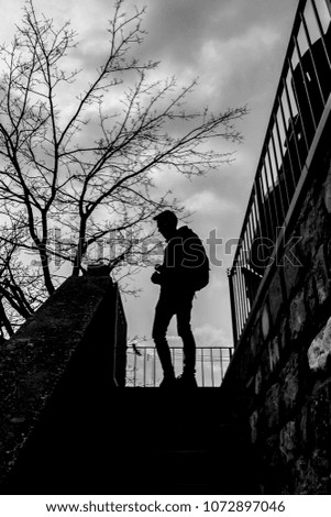 silhouette of young man with cloudy sky background black and white
