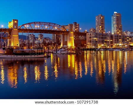 Vancouver cityscape at night. Colorful city night with skyscrapers and marina with boats.