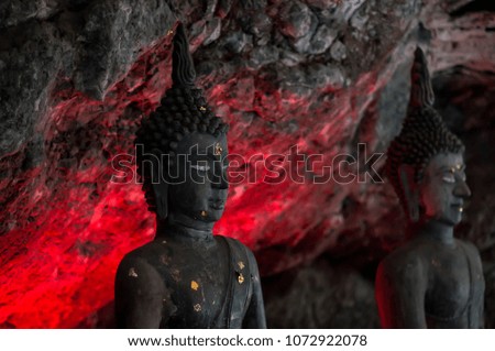 Buddha, in ancient caves, red light shines through the back.
Ban Tham Cave, a tourist attraction in Kanchanaburi, Thailand.