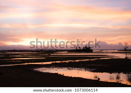Natural Sunset Sunrise Over Field Or Meadow. Bright Dramatic Sky And Dark Ground. Countryside Landscape Under Scenic Colorful Sky At Sunset Dawn Sunrise. Sun Over Skyline