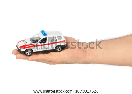 Hand with toy police car isolated on white background