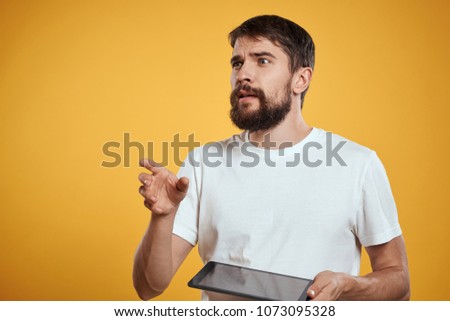 man with touch pad on yellow background                               