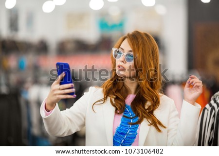 Businesswoman in glasses makes selfie on phone. Concept, shopping.