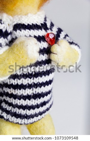 handmade wool toy lion with red heart and striped wool jumper standing