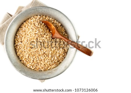 dry oatmeal flakes in metal bowl on white background. Isolated. Top view. Copyspace
