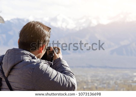 photographer taking landscape photo of himalayas mountain hill