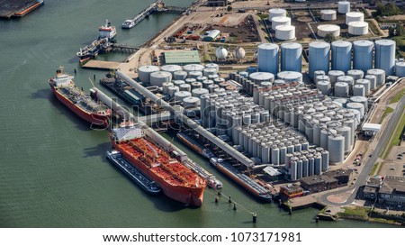 Aerial view of oil tankers moored at an oil storage silo terminal port. Royalty-Free Stock Photo #1073171981