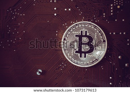 Bitcoin Cryptocurrency on motherboard or electronic computer processor board.