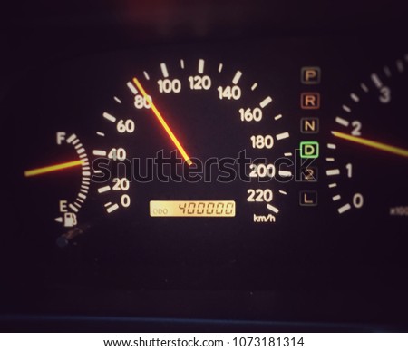 Car dashboard displays 400,000 kilometers driven. Accumulated distances show in the control panel of car. Maintenance alert after long distance use of vehicle.