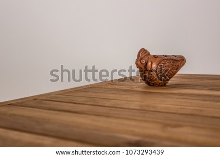 Okarina ceramic handmade folk music instrument on wooden table texture and empty white space for copy or text
