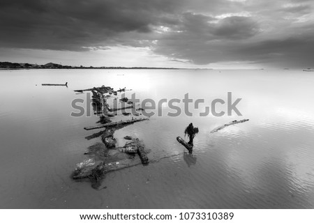 An old shipwreck boat abandoned stand on beach or Shipwrecked off the coast of Thailand. black and white picture 