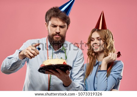 woman looking at cake, man in blue cap                              