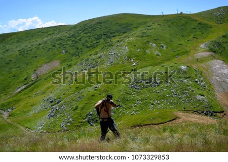 Lonely photographer taking a photo on a mountain hill