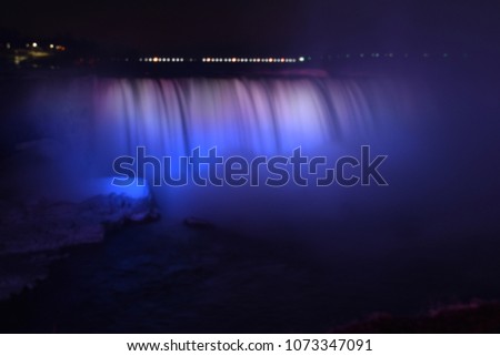 Colorful illuminated Niagara Waterfalls at night in Ontario, Canada