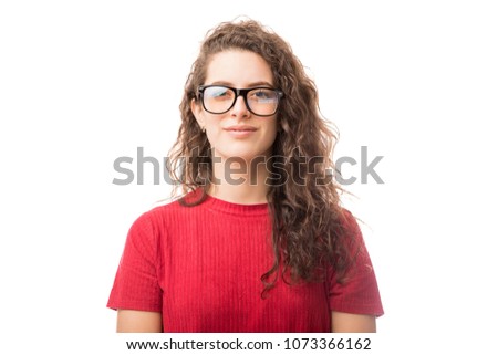 Young nerdy woman with glasses standing against white background and making an eye contact
