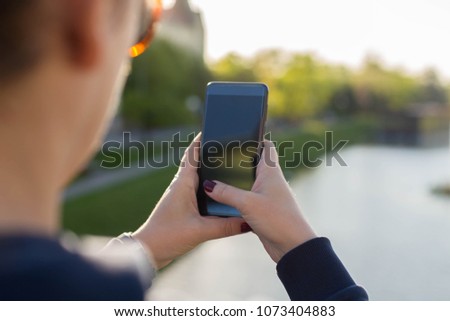 Girl making pictures of a city river